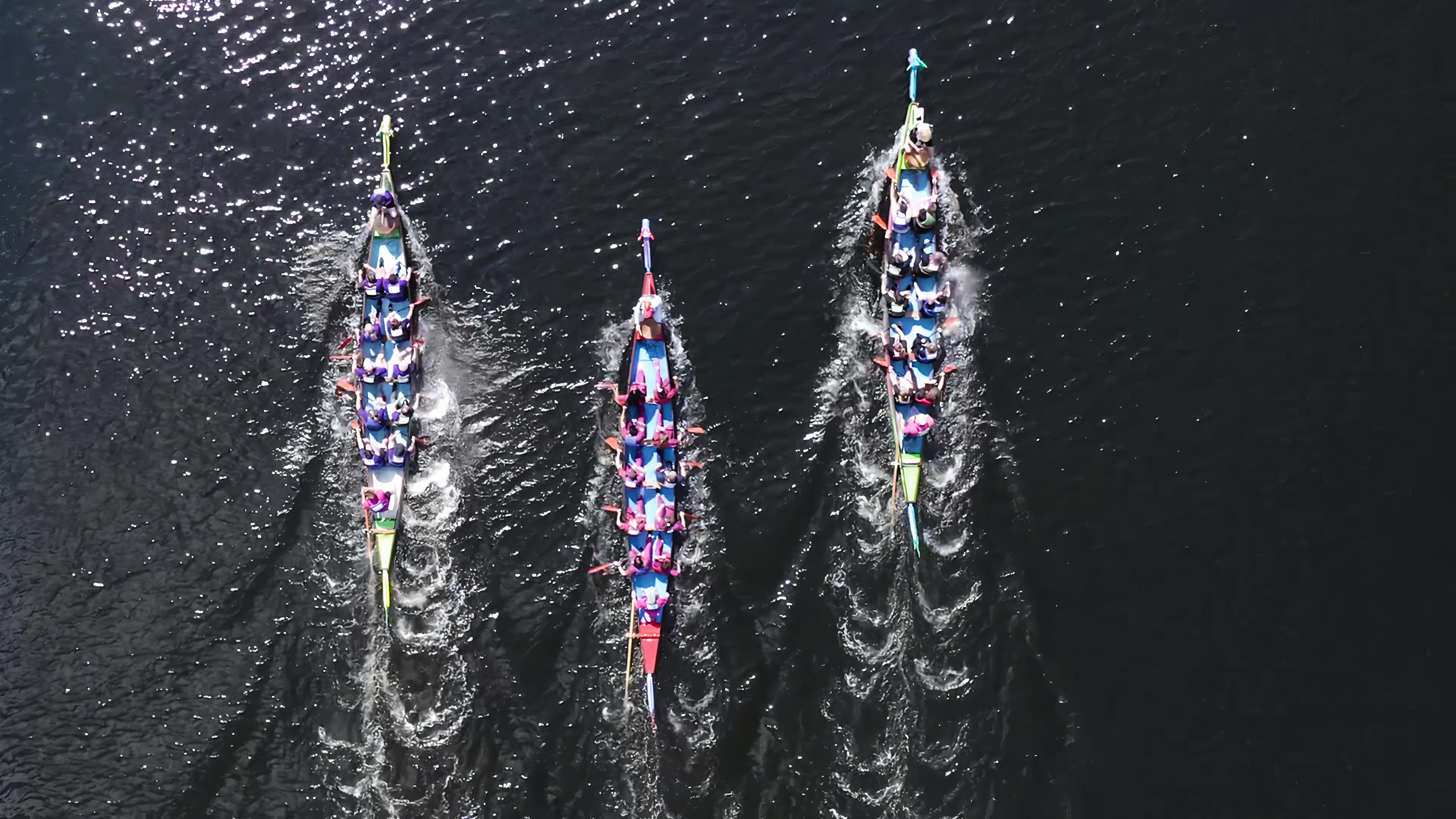 Three dragon boats racing