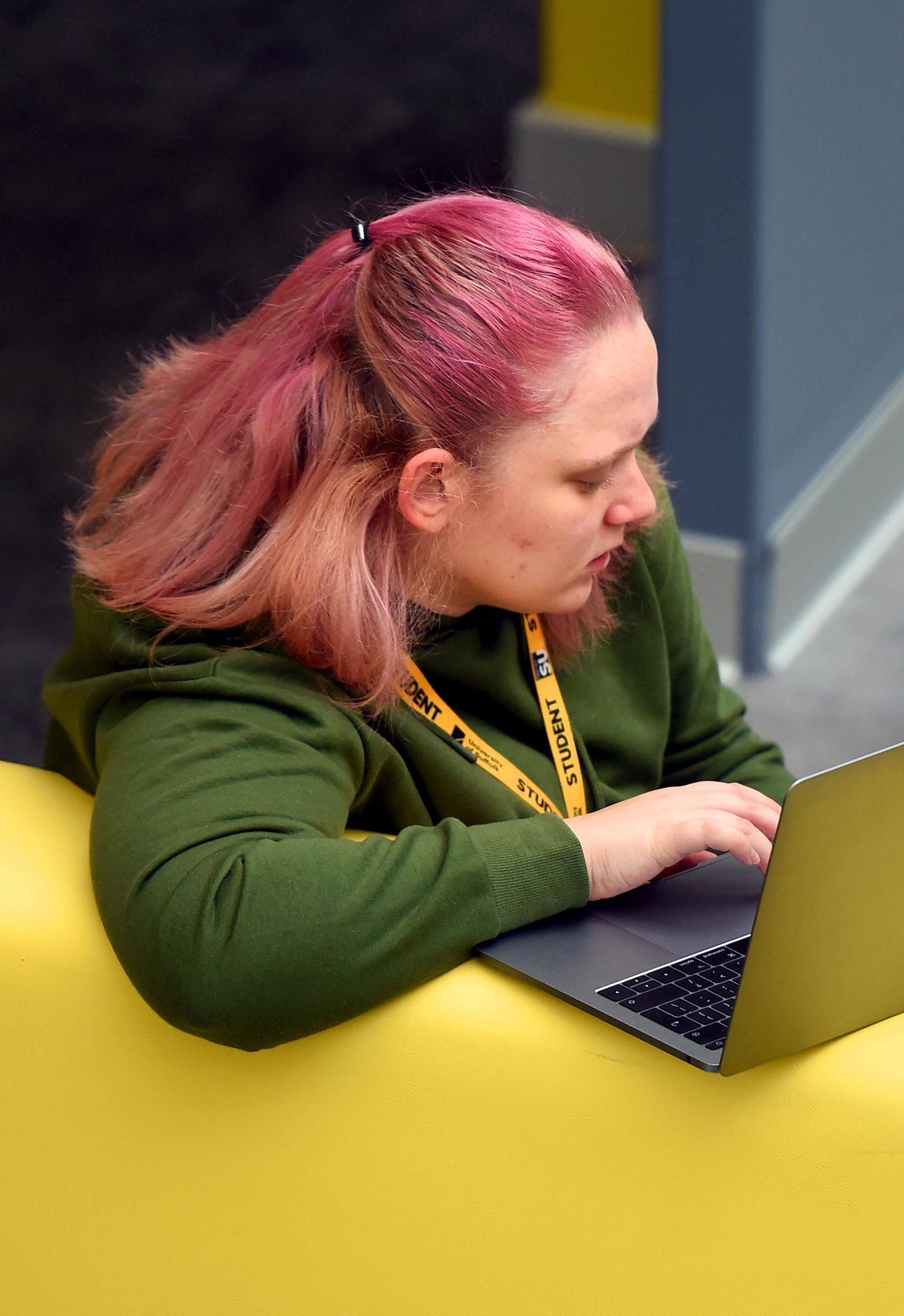 A student sitting with a laptop